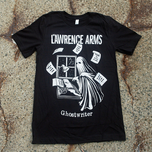 Photo of a black tshirt against a grey asphalt speckled background. The tshirt says the lawrence arms across the chest in white text. Below that is a graphic of a ghost standing near a window. There is a typewriter and a lamp over the typewriter. The ghost is typing something, and pieces of paper are arranged around the ghost in the air in a circular shape. Below the graphic in white text reads "ghostwriter".