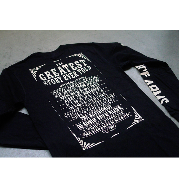close up image of the back of a black longsleeve shirt lying on a grey background. The back of the shirt sort of looks like a rectangular circus flyer, it says the greatest story ever told. Below that it lists the tracklist for the album. The right sleeve says the lawrence arms in white text.