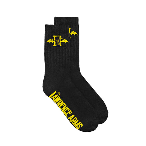 Image of black socks against a white background. The top of the socks have a yellow the lawrence arms logo on them which is an hourglass with wings. The bottom of the socks in yellow text say the lawrence arms.