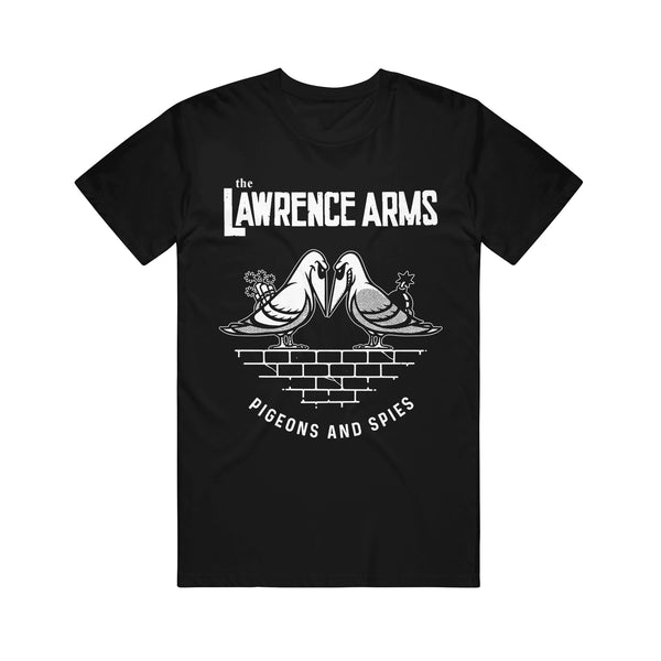 Image of the front of a tshirt against a white background. The front of the shirt across the chest in white text reads the lawrence arms. Below that is a graphic of two pigeons face to face with evil smiles on their faces. One is holding flowers behind its back, the other a bomb. They are standing on bricks. Below this in white text reads "pigeons and spies".
