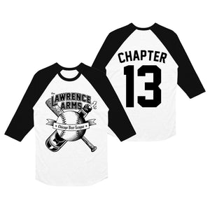 Image of the front and back of a black and white baseball tee against a white background. The front of the shirt says The lawrence arms in black text with a white outline. Below that is an image of a baseball with a bat and beer crossing over each other behind the baseball. There is a banner over the baseball that says Chicago beer league. The back of the shirt says Chapter 13 in black text. the 13 is printed largely, like a baseball jersey style. 